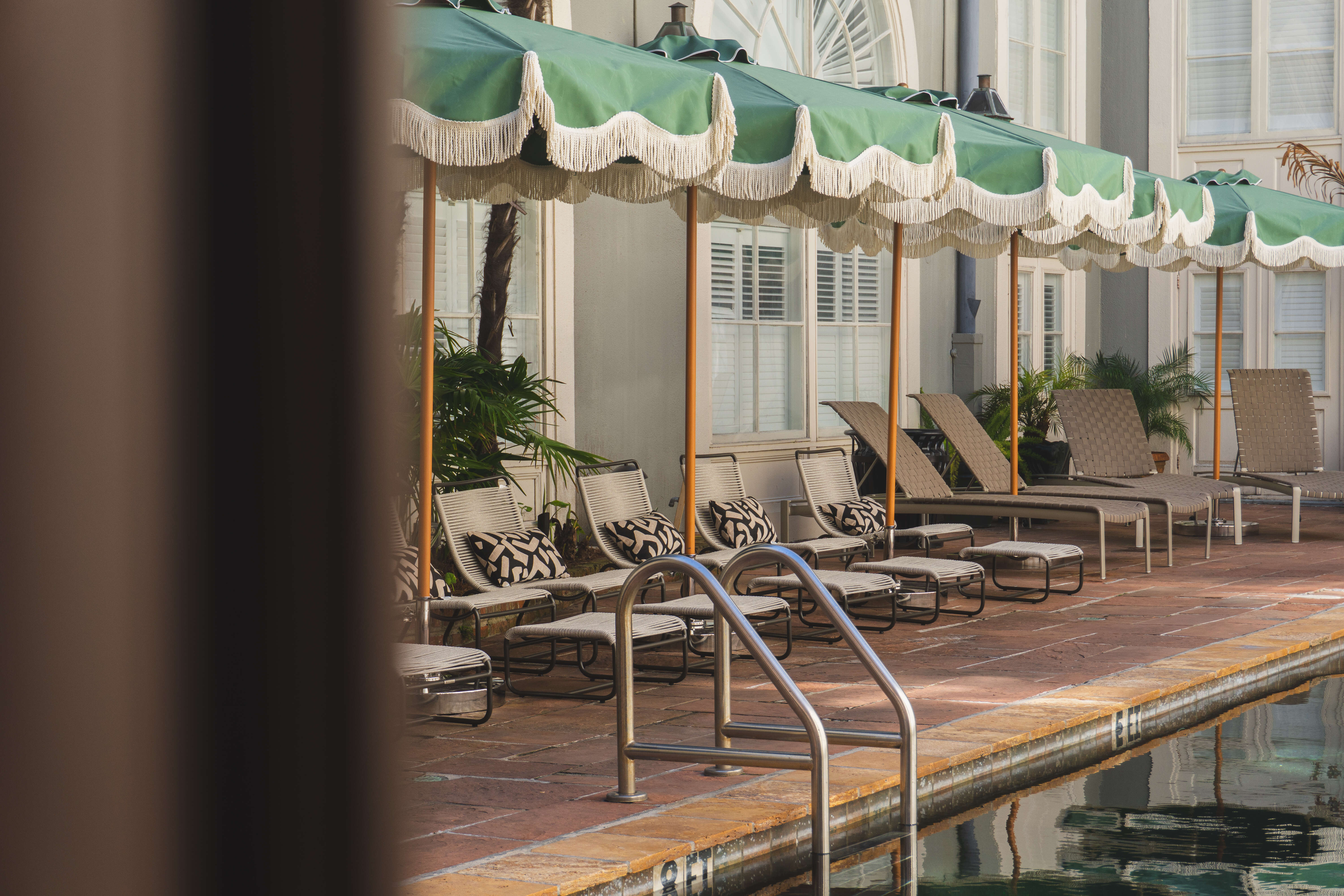 A pool area with lounge chairs and umbrellas