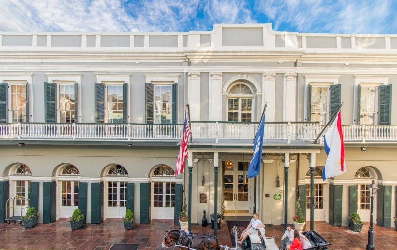a horse-drawn carriage in front of Bourbon Orleans hotel