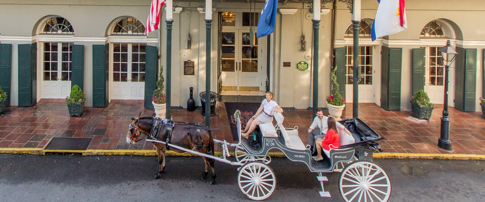 a horse-drawn carriage in front of Bourbon Orleans hotel