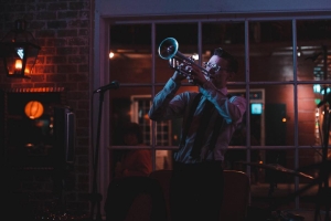 a man in a dark club playing a trumpet
