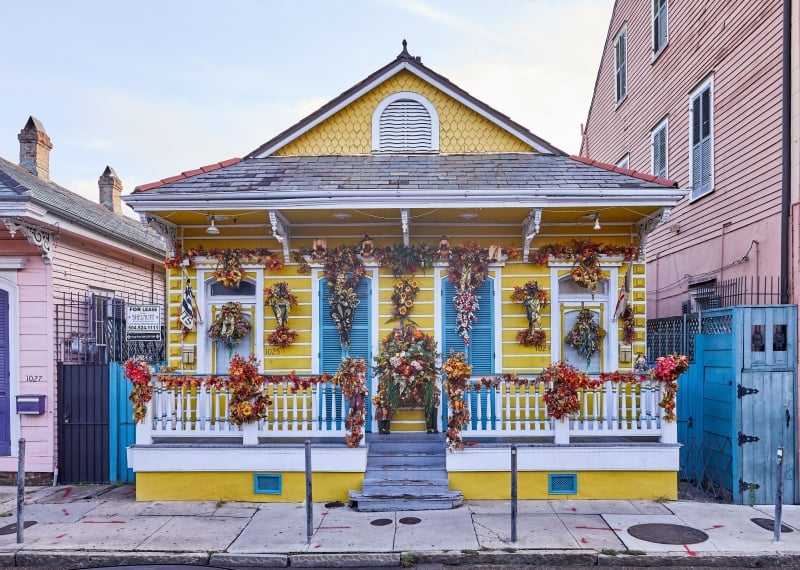 A yellow house decorated for Mardi Gras