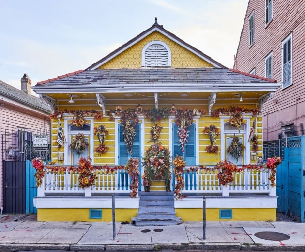 A yellow house decorated for Mardi Gras