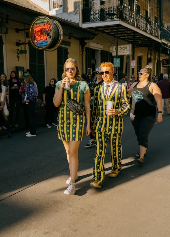 Couple in Mardi Gras Outfits Walking down Bourbon Street