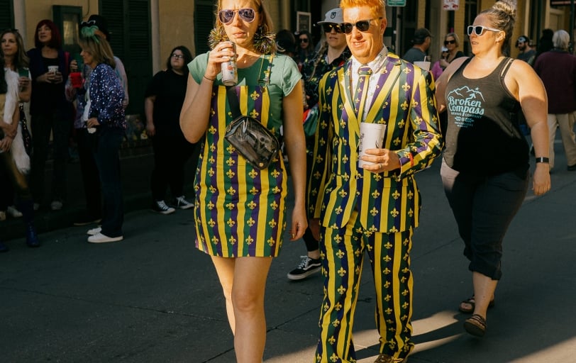 Couple in Mardi Gras Outfits Walking down Bourbon Street